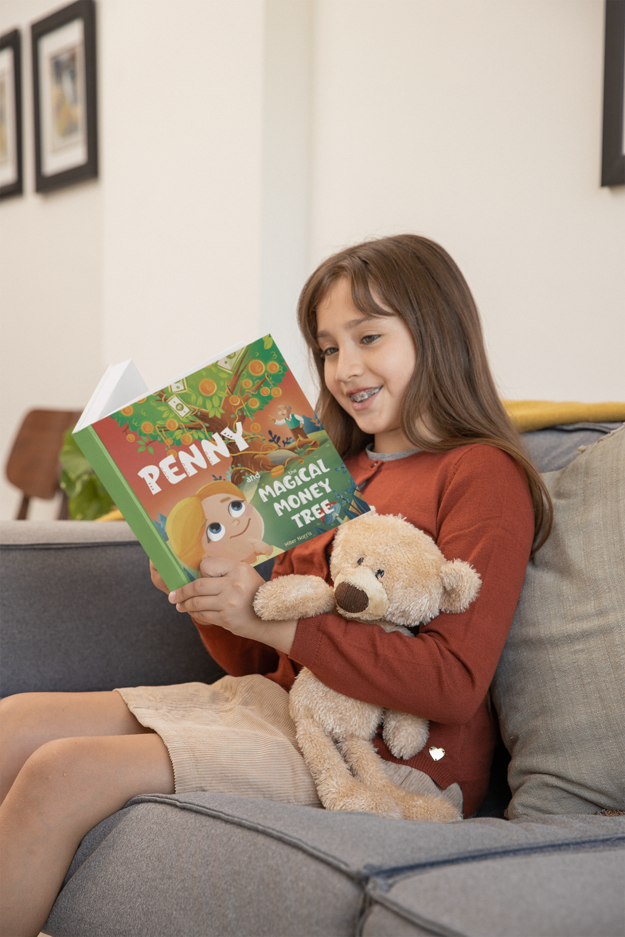 Girl reading Penny and the Magical Money Tree on the couch